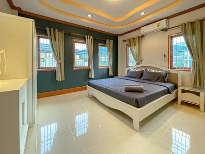 a bedroom with a bed in a room with windows at The Beige Pool Villa Bang Tao Phuket in Ban Thalat Choeng Thale