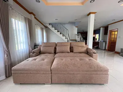 a large brown couch in a living room with stairs at The Beige Pool Villa Bang Tao Phuket in Ban Thalat Choeng Thale