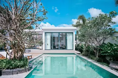 a swimming pool in front of a house with trees at Étoile Kata Luxury Pool Villas by Astra in Kata Beach