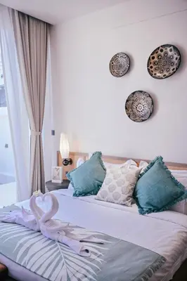 a bedroom with a bed with a swan on it at Étoile Kata Luxury Pool Villas by Astra in Kata Beach