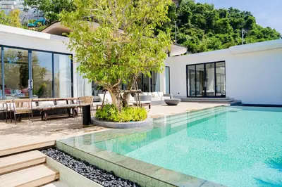 a swimming pool in a house with a tree at Étoile Kata Luxury Pool Villas by Astra in Kata Beach