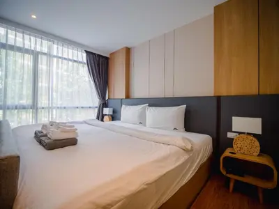 a bedroom with a large white bed with a window at Wyndham Garden 1220 Modern Studio Next to Naithon in Phuket Town