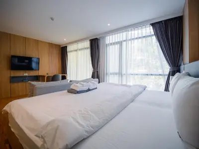 a bedroom with a large white bed with a window at Wyndham Garden 1220 Modern Studio Next to Naithon in Phuket Town