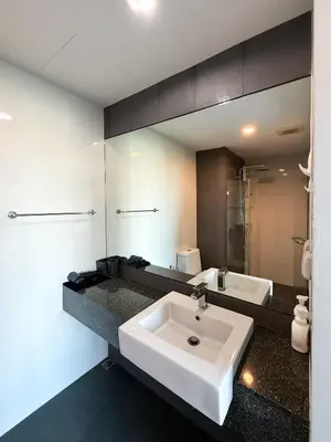 a bathroom with a white sink and a mirror at 6th Avenue 2 bedroom in Surin Beach