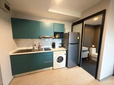 a kitchen with green cabinets and a sink and a dishwasher at 6th Avenue 2 bedroom in Surin Beach
