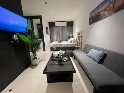 a living room with a couch and a tv at Utopia Central in Ban Ket Ho