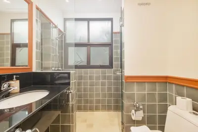 a bathroom with a shower and a toilet and a sink at Spacious Villa with Pool, Garden & Club facilities in Layan Beach