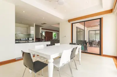 a white dining room with a white table and chairs at Spacious Villa with Pool, Garden & Club facilities in Layan Beach
