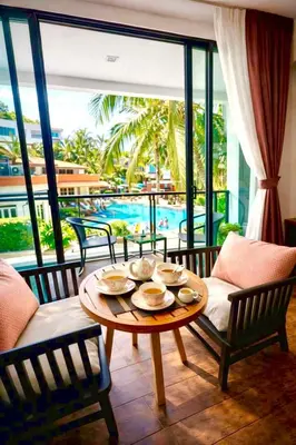 a dining room with a table and chairs and a pool at Beautiful Pool View Studio in Kata in Kata Beach
