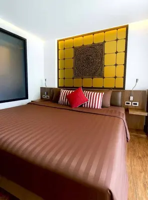 a bedroom with a large bed and a flat screen tv at Beautiful Pool View Studio in Kata in Kata Beach