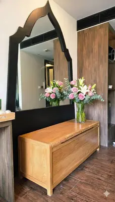 a bathroom with a vanity with flowers in a mirror at Beautiful Pool View Studio in Kata in Kata Beach