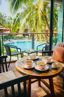 a table with four cups of tea on it with a pool at Beautiful Pool View Studio in Kata in Kata Beach