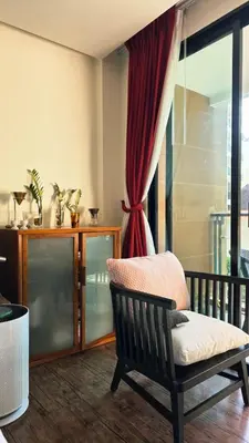 a living room with a chair and a window at Beautiful Pool View Studio in Kata in Kata Beach