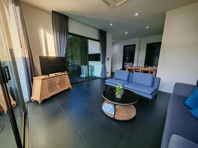 a living room with a blue couch and a table at Chalong Modern 2 bedroom pool villa in Ban Suan