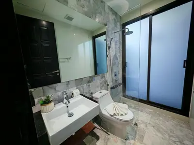 a bathroom with a toilet and a sink and a mirror at Chalong Modern 2 bedroom pool villa in Ban Suan
