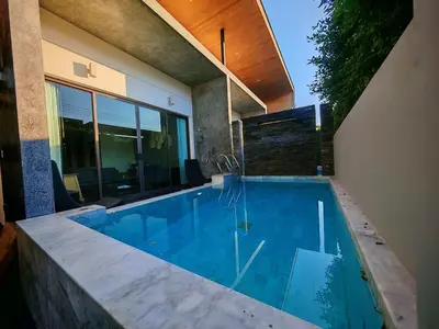 a swimming pool in front of a house at Chalong Modern 2 bedroom pool villa in Ban Suan