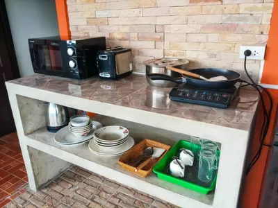 a kitchen counter with a microwave and some dishes at Kata Lina rooftop in Kata Beach