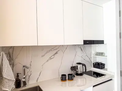 a kitchen with white cabinets and a counter top at Sunshine Layan Beach Resort studio #84191 in Layan Beach
