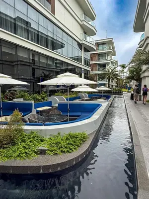 a row of tables and umbrellas in a canal in a building at Sunshine Layan Beach Resort studio #84191 in Layan Beach