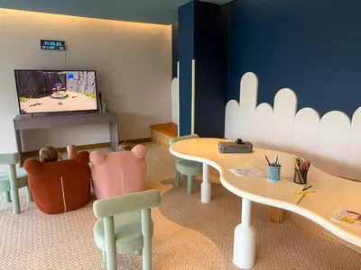 a play room with two tables and a tv at Sunshine Layan Beach Resort studio #84191 in Layan Beach