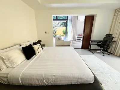 a large white bed in a room with a desk at Tropical 2 BR Pool Villa - Baan Wana 177-15 in Koh Lone