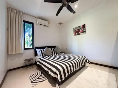 a bedroom with a bed and a ceiling fan at Tropical 2 BR Pool Villa - Baan Wana 177-15 in Koh Lone