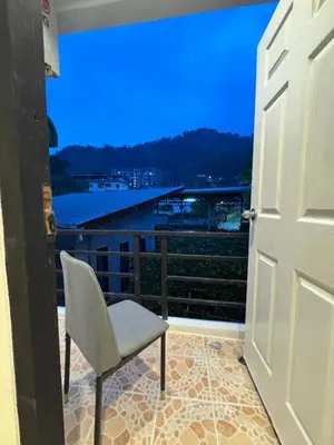 a door leading to a balcony with a chair at Chapter 26 in Patong Beach