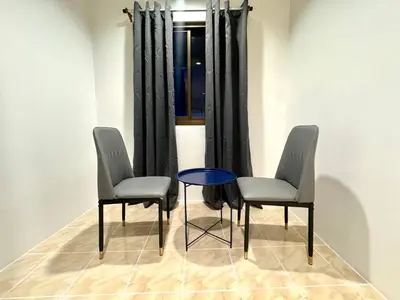 two chairs and a table in a room with a window at Chapter 26 in Patong Beach