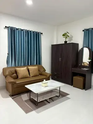 a living room with a couch and a coffee table at AN Airport Guesthouse in Nai Yang Beach