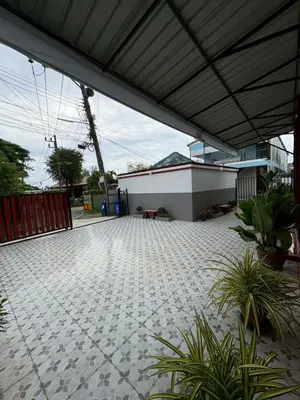 a patio with awning and plants and a building at AN Airport Guesthouse in Nai Yang Beach