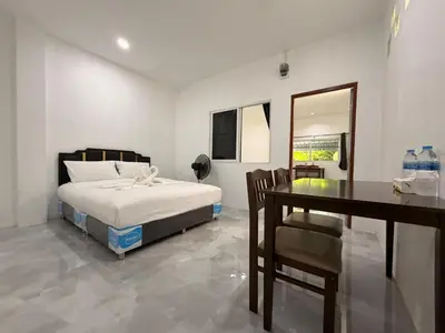 a bedroom with a bed and a table and chairs at Jasmine Residence in Patong Beach