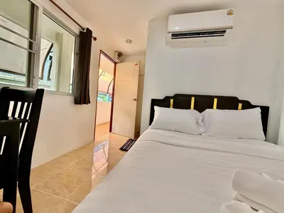 a bedroom with a white bed and a window at Jasmine Residence in Patong Beach