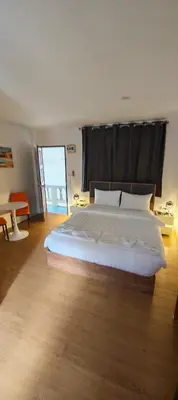 a bedroom with a large white bed with a black curtain at Tiger Nanai guest house in Patong Beach