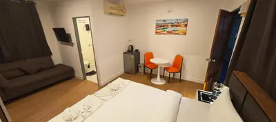 a bedroom with a bed and a table and chairs at Tiger Nanai guest house in Patong Beach