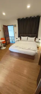 a bedroom with a large bed with a large window at Tiger Nanai guest house in Patong Beach