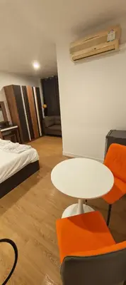 a room with a table and a bed and a table and chairs at Tiger Nanai guest house in Patong Beach