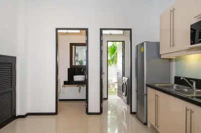 a kitchen with a refrigerator and a door to a room at Private villa at Oxygen Bangtao -pool garden BBQ in Ban Thalat Choeng Thale
