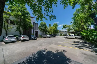 a parking lot with cars parked in front of a building at Private villa at Oxygen Bangtao -pool garden BBQ in Ban Thalat Choeng Thale