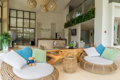 a lobby with wicker chairs and a table at Recenta Suite Phuket Suanluang in Phuket Town