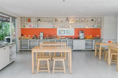 a large kitchen with wooden tables and chairs at Recenta Suite Phuket Suanluang in Phuket Town