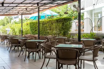 a row of tables and chairs on a patio at Recenta Suite Phuket Suanluang in Phuket Town