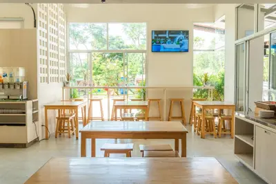 a dining room with tables and chairs and windows at Recenta Suite Phuket Suanluang in Phuket Town