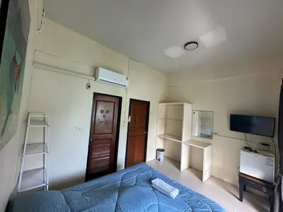 a bedroom with a bed and a tv and a ladder at Nanworld travel sea view room in Phi Phi Don