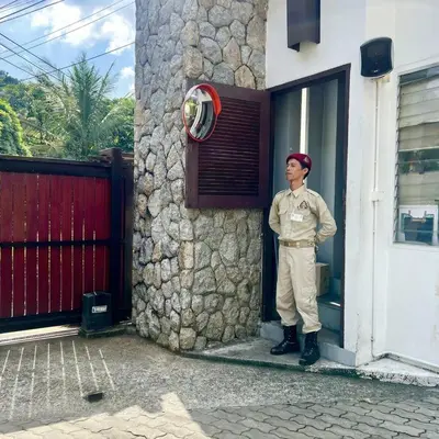 a man in uniform standing outside of a building at Kamala Hills Ocean Breeze 3 Bedroom Loft with Access to 3 Pools in Kamala Beach