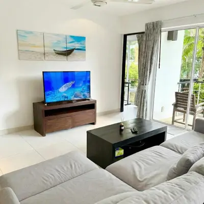 a living room with a couch and a flat screen tv at Kamala Hills Ocean Breeze 3 Bedroom Loft with Access to 3 Pools in Kamala Beach