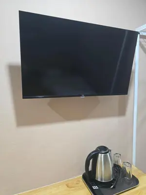 a tv hanging on a wall with a tea kettle at Yolo\u6d77\u9493\u4ff1\u4e50\u90e8\u516c\u5bd3 in Ban Bang Chak