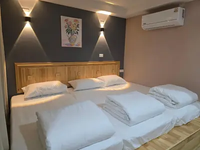 two beds in a room with white sheets and pillows at Yolo\u6d77\u9493\u4ff1\u4e50\u90e8\u516c\u5bd3 in Ban Bang Chak