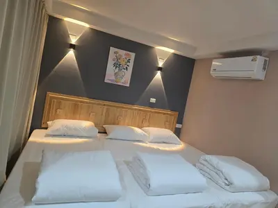two beds in a room with two white pillows at Yolo\u6d77\u9493\u4ff1\u4e50\u90e8\u516c\u5bd3 in Ban Bang Chak