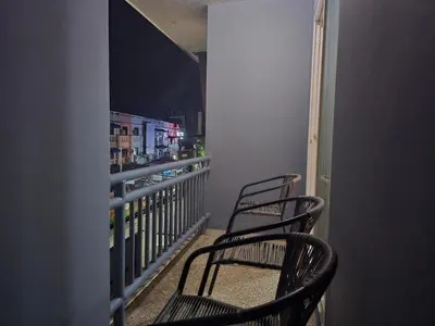 two chairs sitting on a balcony at night at Yolo\u6d77\u9493\u4ff1\u4e50\u90e8\u516c\u5bd3 in Ban Bang Chak