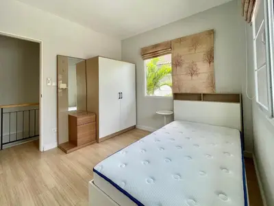 a bedroom with a bed and a cabinet and a window at Cozy Serene Home Quiet Garden for a Peaceful Stay in Phuket Town